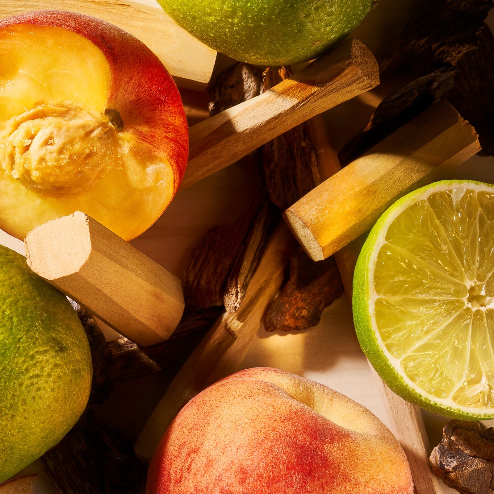 Assorted fruits including apples, a peach, and a lime on a wooden surface.